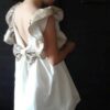 Sukienka ekri z cekinami dla dziewczynki, modelka - tył