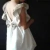 Sukienka ekri z cekinami dla dziewczynki, modelka - tył