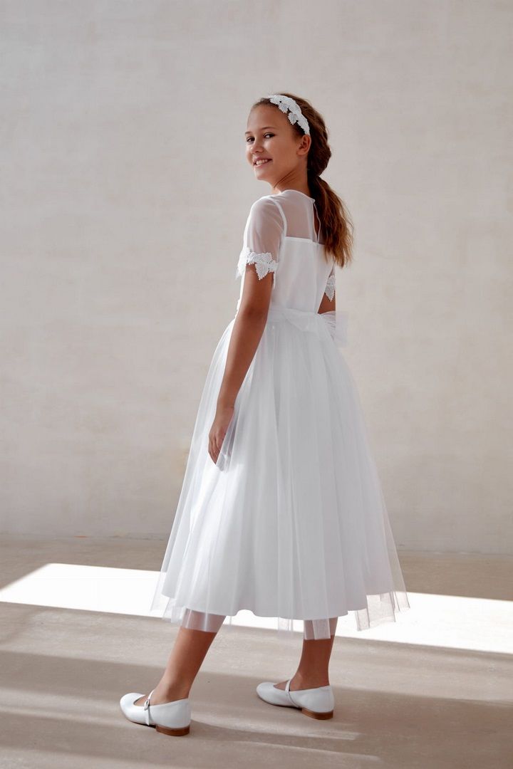 Biała sukienka do Komunii przyozdobiona gipiurowymi listkami, widok na tył sukienki.