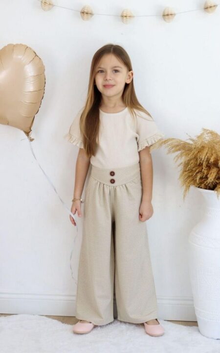 Beżowy komplet z wiskozy dla dziewczynki, składający się z bluzki z falbankami i szerokich spodni.
