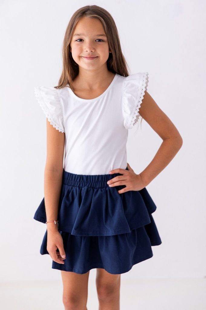 Elegancka biała bluzka dla dziewczynki z falbanami, idealna do szkoły.