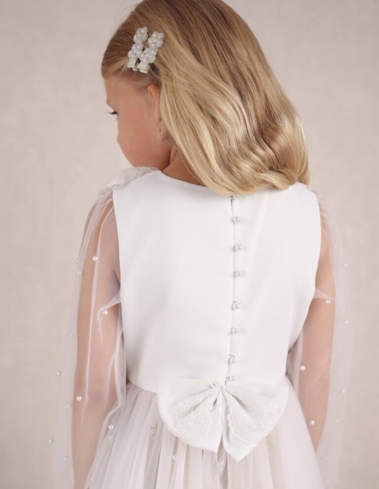 Biała tiulowa sukienka dla dziewczynki z tylnym zapięciem na guziki i ozdobnym kokardą.