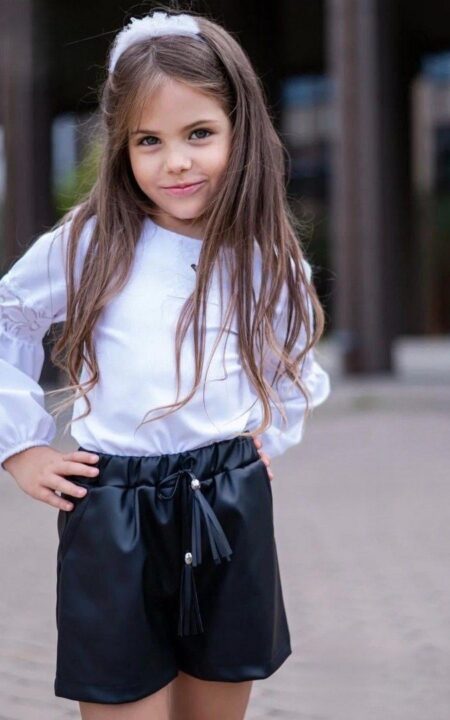 Biała bluzka z koronkową wstawką dla dziewczynki, idealna na codzienne stylizacje.