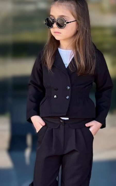 Czarny garnitur dla dziewczynki składający się z eleganckiej bluzki i spodni, idealny na specjalne okazje.