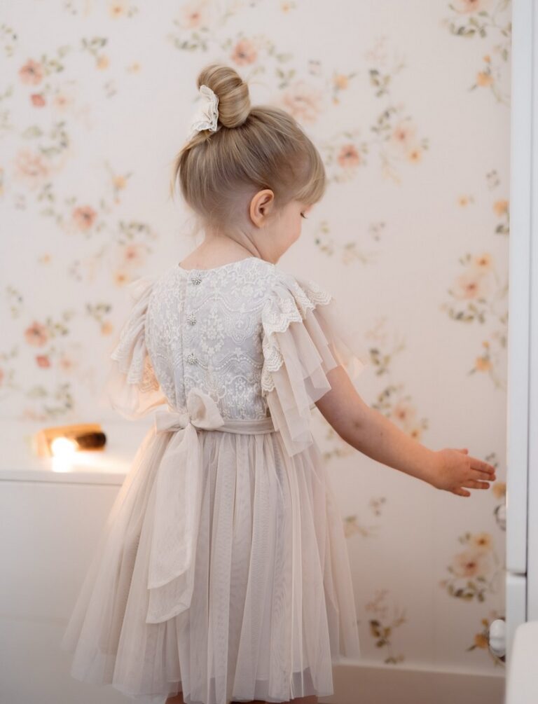 Delikatna wiskozowa sukienka dla dziewczynki z koronkowymi rękawami, w kolorze beżowym, bez kokardy.