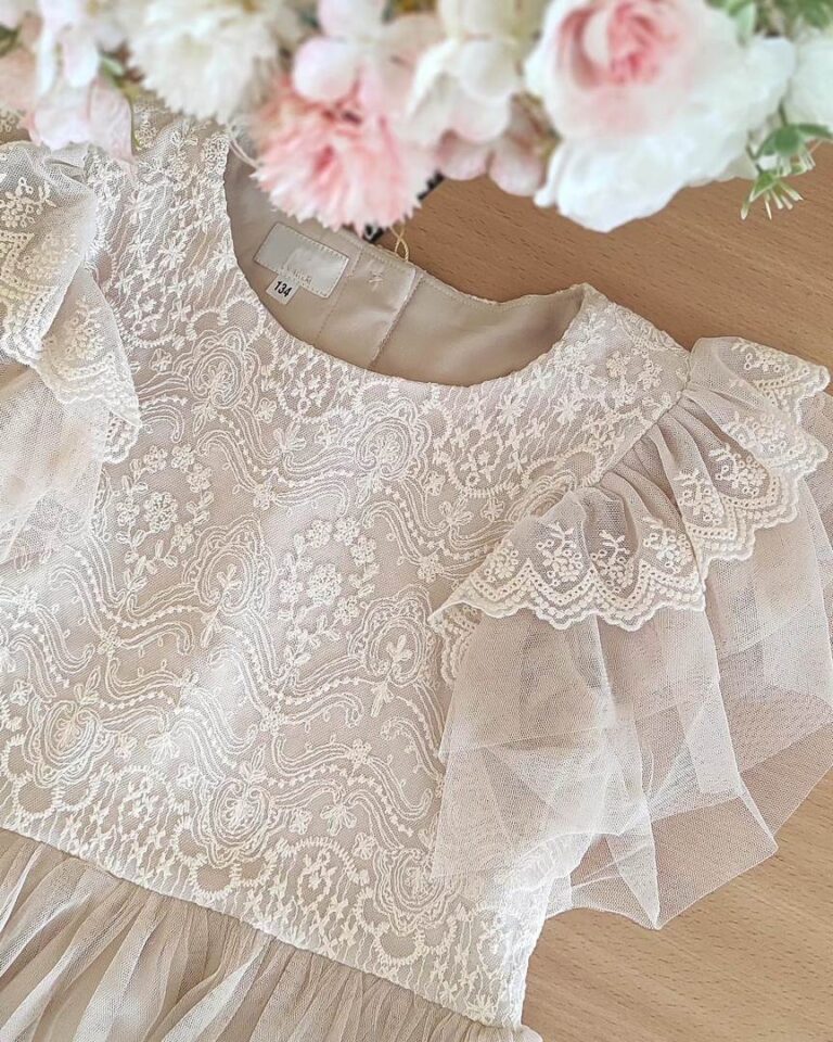 Delikatna wiskozowa sukienka dla dziewczynki z koronkowymi detalami i falbanami na rękawach, idealna na specjalne okazje.