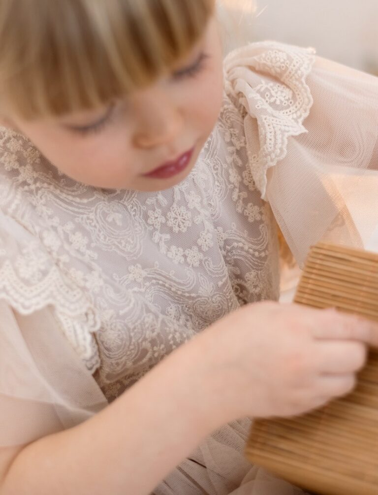 Delikatna wiskozowa sukienka dla dziewczynki z koronkowym wykończeniem na górze, idealna na specjalne okazje.