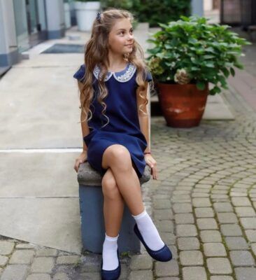 Granatowa sukienka dla dziewczynki z białym kołnierzykiem, idealna na eleganckie okazje.
