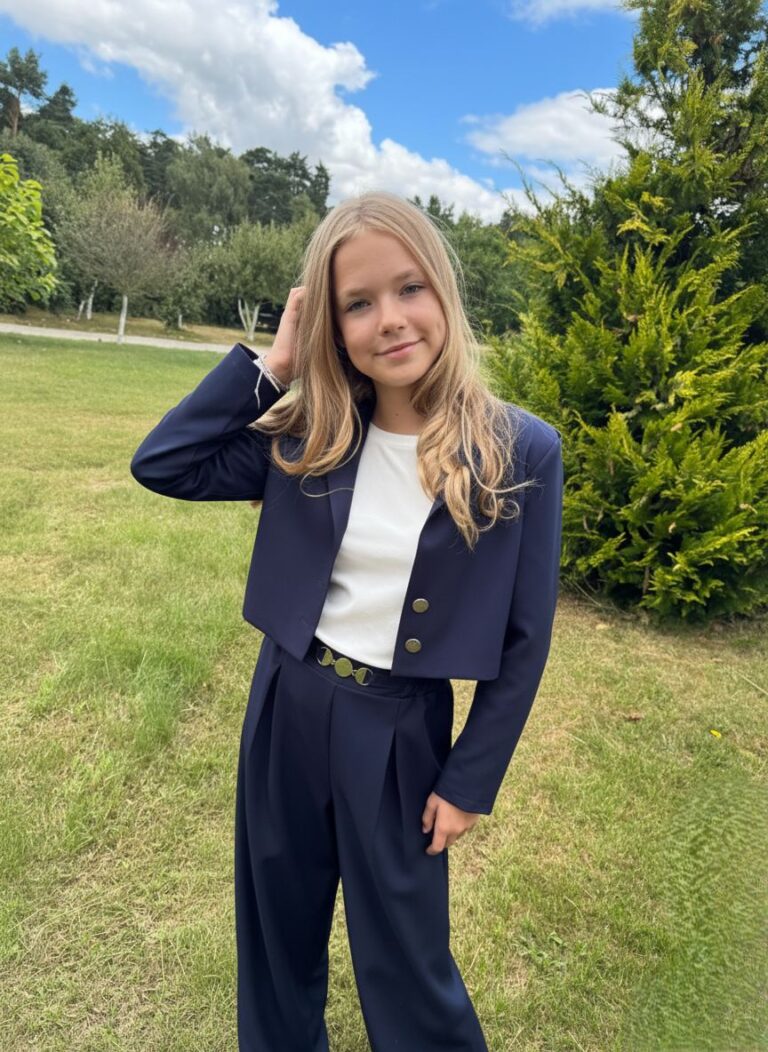 Granatowy garnitur dla dziewczynki z krótką marynarką i szerokimi spodniami, idealny na eleganckie okazje.