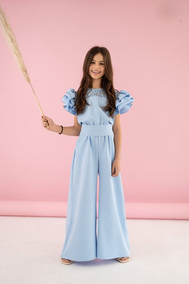 Kombinezon dla dziewczynki w kolorze niebieskim z koronkowymi plecami i bufkami na rękawach.