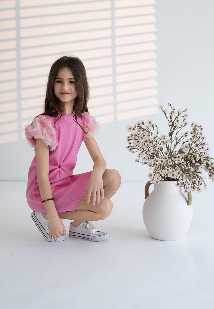 Różowa sukienka dla dziewczynki z ozdobnymi rękawami, idealna na letnie przyjęcia i codzienne wyjścia.