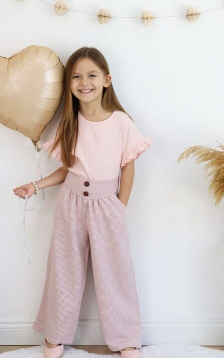 Różowy komplet wiskozowy dla dziewczynki z bluzką z falbanami i szerokimi spodniami w kratkę.