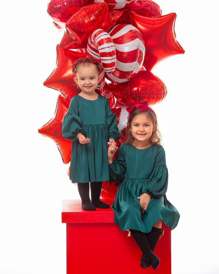 Satynowa sukienka w kolorze butelkowej zieleni dla małej dziewczynki, idealna na specjalne okazje.