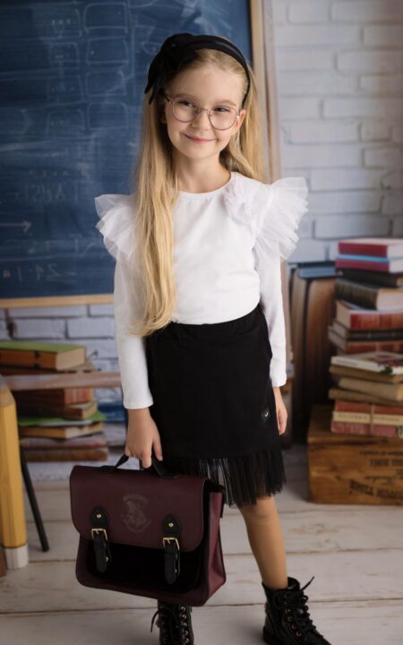 Czarna spódnica bawełniana z tiulem, idealna dla dziewczynki, zestawiona z białą bluzką z falbanami.