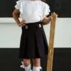 Czarna spódnica szkolna z plisami i literą B na pasku, idealna na zajęcia szkolne.