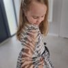Sukienka w zwierzęcy print zebra dla dziewczynki, z delikatnymi rękawami i czarnym paskiem w talii.