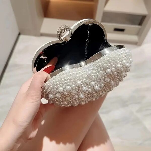 Torebka w kształcie serca, ozdobiona perłami, idealna na eleganckie wyjścia.