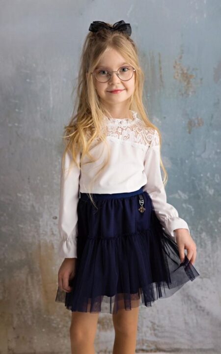 Biała bluzka z koronkowym wykończeniem oraz granatowa spódnica z tiulu dla dziewczynki. Idealny zestaw na specjalne okazje.