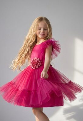 Amarantowa sukienka tiulowa dla dziewczynki z ozdobnym kwiatem na talii i falbanami.