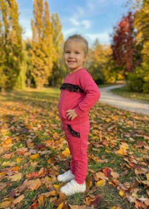 Bawełniany dres dla dziewczynki w kolorze amarantowym z ozdobnym paskiem na bluzie i kieszeniami.