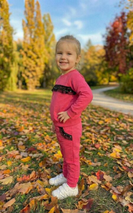 Bawełniany dres dla dziewczynki w kolorze amarantowym z ozdobnym paskiem na bluzie i kieszeniami.