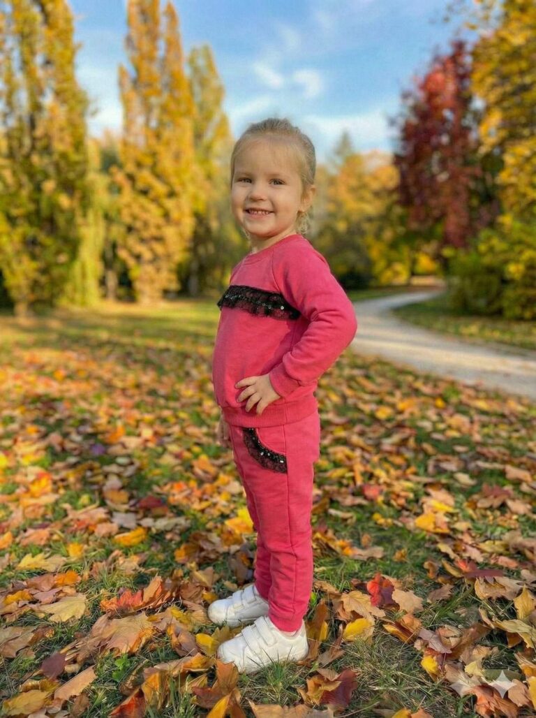 Bawełniany dres dla dziewczynki w kolorze amarantowym z ozdobnym paskiem na bluzie i kieszeniami.