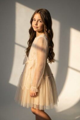 Beżowa sukienka tiulowa dla dziewczynki z kokardą, idealna na specjalne okazje.