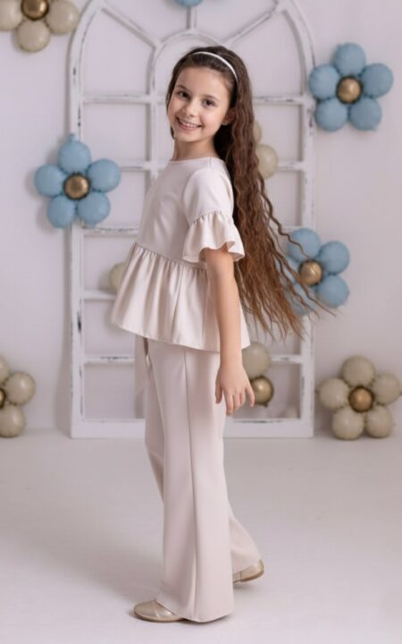 Beżowy zestaw składający się z bluzki z falbanami i spodni, idealny na codzienne stylizacje dla dziewczynki.