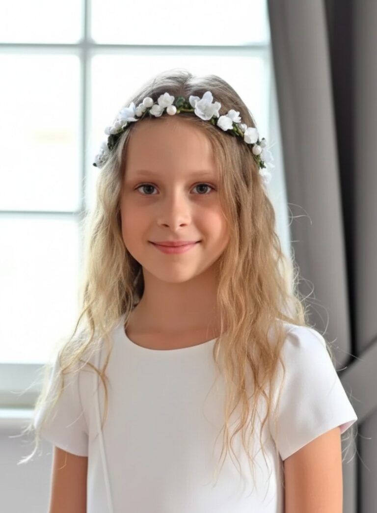 Delikatny wianek komunijny na dziewczynce z białymi kwiatami, idealny na uroczystość.