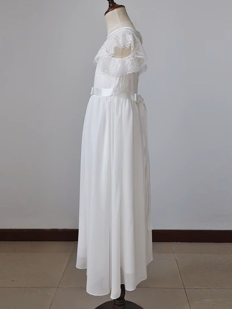 Długa biała sukienka do komunii z koronkowymi rękawami i paskiem w talii.