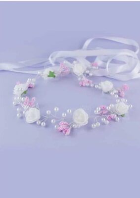 Wianek komunijny z białymi różami, różowymi akcentami i perłami, ozdobiony wstążką.