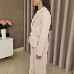 Taliowany garnitur w kolorze łososiowym dla dziewczynki z kokardką, idealny na eleganckie okazje.