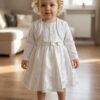 Komplet ecru dla dziewczynki składający się z sukienki z haftem i białego bolerka, idealny na uroczystości.