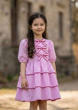 Różowa bawełniana sukienka w kratę vichy z falbanami i kokardkami na przodzie, idealna na letnie dni.