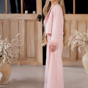 Różowy garnitur dla dziewczynki z krótką marynarką i szerokimi spodniami, idealny na specjalne okazje.