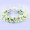Wianek dla dziewczynki z białymi i zielonymi kwiatami, idealny na uroczystości i specjalne okazje.