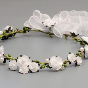 Wianek dla dziewczynki z białymi kwiatami i zielonymi liśćmi, ozdobiony białą wstążką.